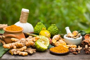 Turmeric powder,Turmeric in Mortar Grinder drugs and ingredient herbs on wooden background
